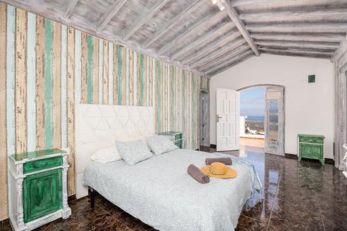 阿索马达Villa Oasis de Asomada的一间卧室,配有一张床,上面有帽子