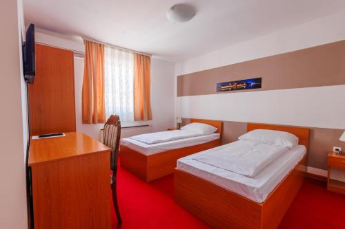 奥西耶克Pansion Strossmayer的酒店客房配有两张床和一张书桌