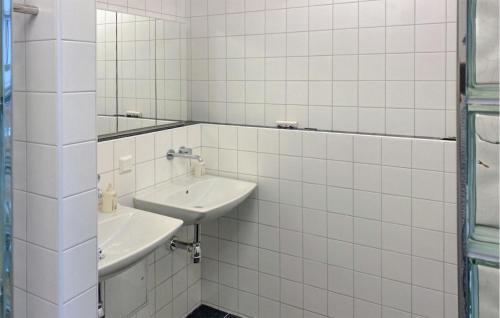瓦尔德马什维克Amazing Home In Valdemarsvik With Wifi的白色瓷砖浴室设有两个盥洗盆和镜子