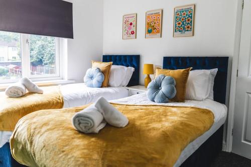 伍尔弗汉普顿Probert- Perfectly Placed- Driveway - 3 bed的客房内的两张床和蓝色枕头