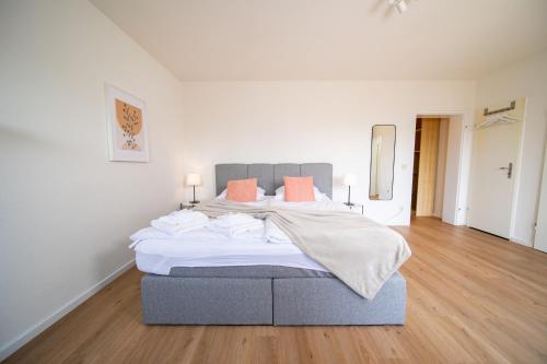 诺伊斯Apartment - Central with kitchen - Balcony - Fair的一间卧室配有一张带橙色枕头的大床