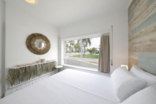 卡巴纳斯·德·塔维拉Royal Cabanas Golf的卧室设有白色墙壁和大窗户