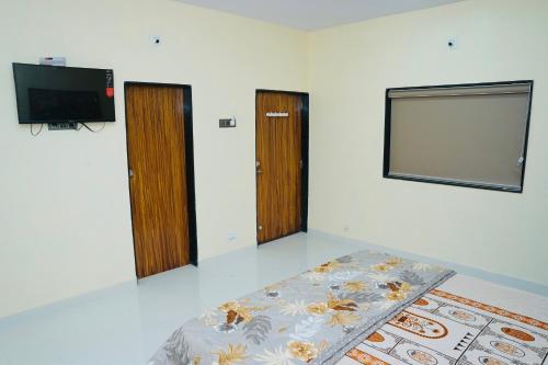 索姆纳特Dwarkesh Farm&Resort的一间设有两扇门、一台电视和一张床的房间