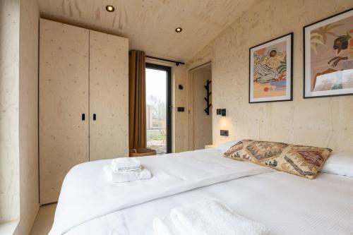 韦斯特卡佩勒Hello Zeeland - Tiny House Zeeuwse Liefde 11的窗户客房内的一张大白色床
