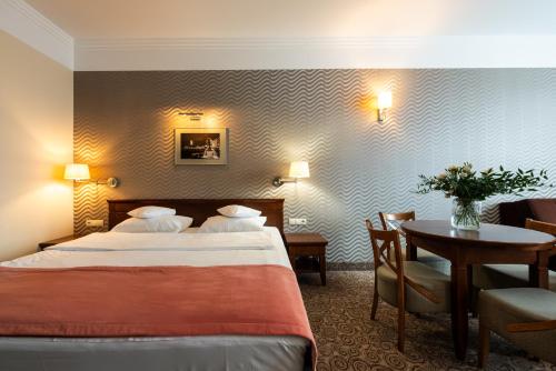 比亚韦斯托克世界语酒店 的酒店客房配有一张床铺和一张桌子。