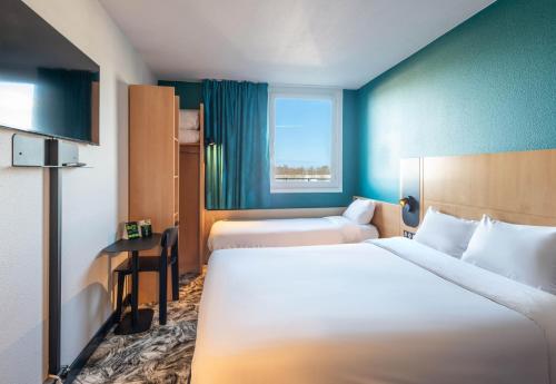 科凯勒B&B HOTEL Calais Terminal Cité Europe 3 étoiles的酒店客房设有两张床和窗户。