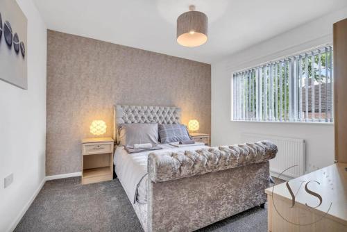 西布罗姆维奇Stylish 3BR Home - Beautiful Garden - Parking的一间卧室配有一张床和一张沙发