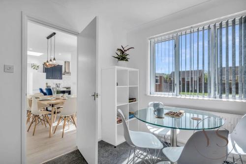 西布罗姆维奇Stylish 3BR Home - Beautiful Garden - Parking的厨房以及带玻璃桌和椅子的用餐室