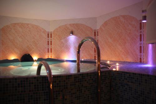 尤尔马拉佩嘎萨必尔斯温泉酒店的浴室设有浴缸和2个水龙头