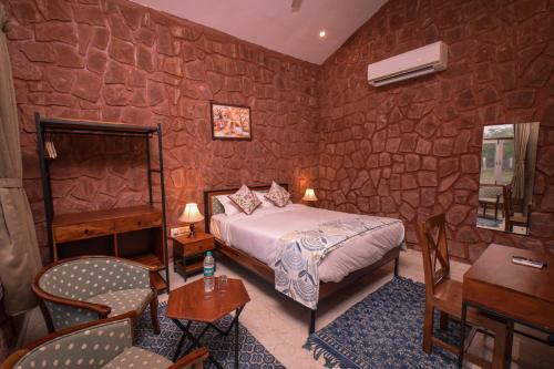 焦特布尔Impian Resorts的一间卧室设有一张床和石墙