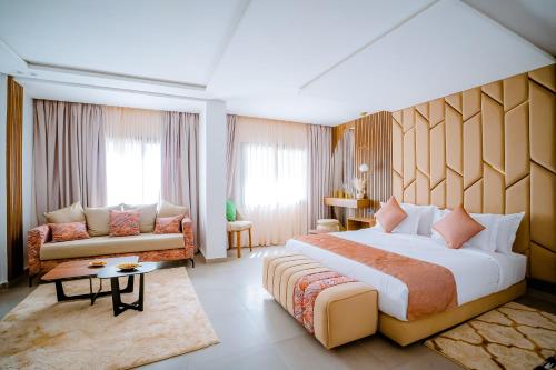 达赫拉TIMAZIN HOTEL DAKHLA的酒店客房设有一张大床和一张沙发。