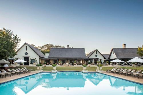 利文斯顿赞比亚维多利亚瀑布皇家利文斯顿安纳塔拉酒店的一座带游泳池和椅子的酒店和一座建筑