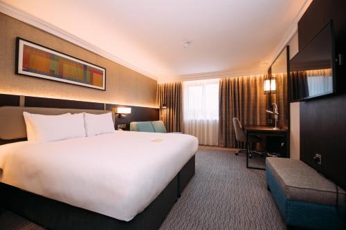 贝尔法斯特贝尔法斯特广场酒店的酒店客房设有一张白色大床和一张书桌