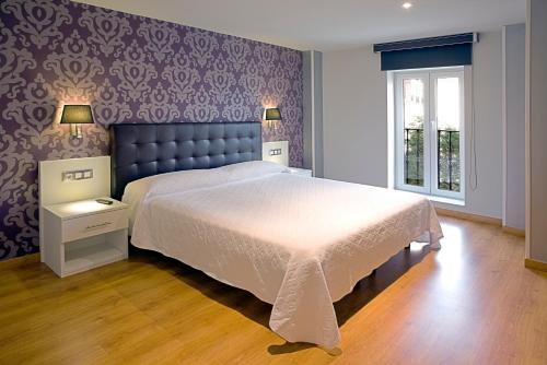 霍兹纳约帕西拉温泉别墅公寓的一间卧室设有一张大床和紫色的墙壁