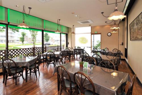 福井福井站前科福库酒店的用餐室设有桌椅和窗户。