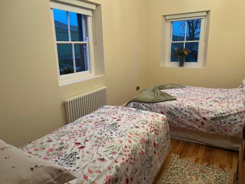 巴林托伊Dunnaglea Cottage, Ballintoy的带2扇窗户的客房内的2张床