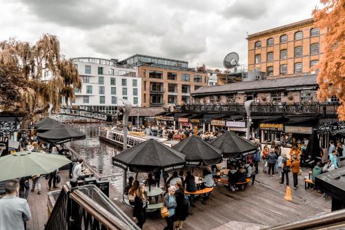 伦敦Camden Town Self Check-in Luxury Rooms的一群人坐在河边码头的桌子上