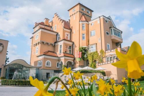 萨尔茨堡蒙切斯泰恩城堡酒店的一座大建筑,前面有黄色的花朵