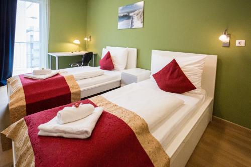 布达佩斯迪威尔第公寓酒店 的酒店客房带两张带红白色枕头的床