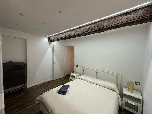伊夫雷亚Residenza Castellazzo的卧室配有白色的床和电视。