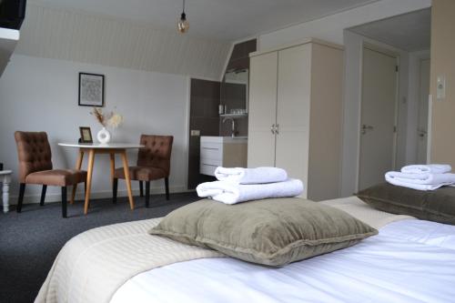 诺德克豪特诺德克豪特亨特瓦彭酒店的一间卧室配有两张床和一张桌椅