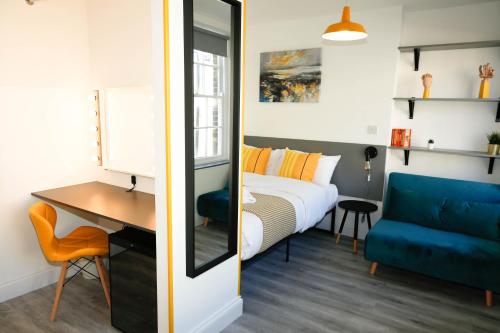 伦敦Camden Town Self Check-in Luxury Rooms的一间卧室配有一张床、一张桌子和一张蓝色的沙发