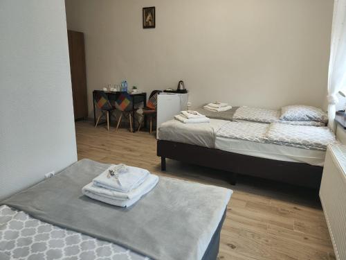 RunowoPałac pod Bocianim Gniazdem的客房设有两张床和一张带毛巾的桌子。