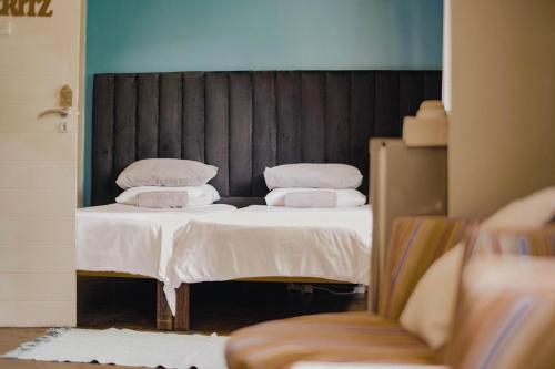 温特和克Kate's Nest Guesthouse的一间卧室配有两张带白色床单和枕头的床。