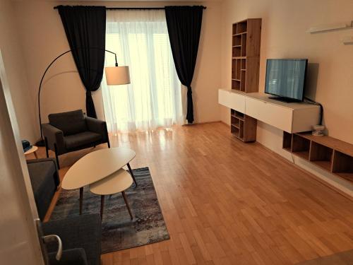 格拉茨Flataid Apartment Elisabethinergasse的一个带桌子和电视的小客厅