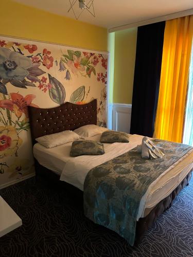 伊斯坦布尔Mavikapı Suit的卧室配有一张墙上鲜花的大床