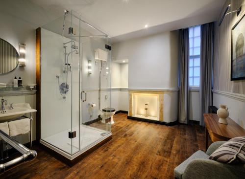 巴斯Abbey Hotel Bath, a Tribute Portfolio Hotel的一间带玻璃淋浴和壁炉的浴室