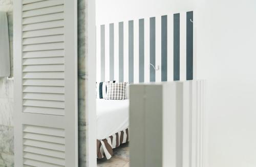 波多黎各大加那利岛海湾景码头公寓 - 仅限成人入住的卧室配有白色床和条纹墙