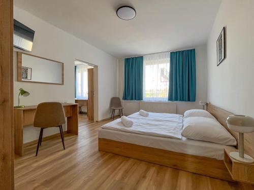 里马夫斯卡索博塔AM Motel的一间卧室配有一张床、一张桌子和一把椅子