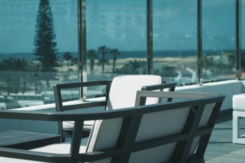 英格兰海滩厄尔巴尔玛酒店的海景阳台上的桌椅