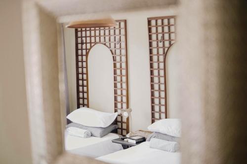 温特和克Kate's Nest Guesthouse的卧室的镜子反射,配有白色枕头和一张床