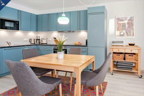 ZirchowHaffblick 1的厨房配有蓝色橱柜和木桌及椅子