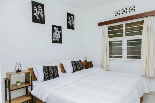 基加利Neza Haven Kigali的卧室配有白色的床和窗户。