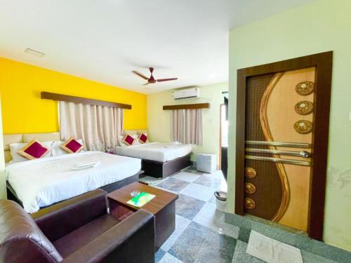 普里Goroomgo Coral Suites Puri Near Sea Beach with Swimming Pool - Parking Facilities的酒店客房,配有床和沙发