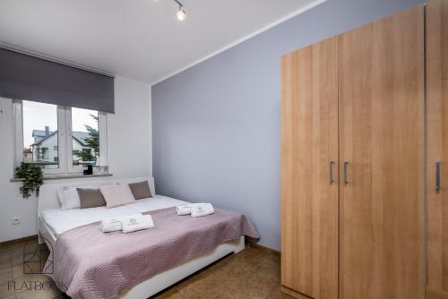 库瑞尼卡慕斯卡Flatbook Apartamenty - Krynica Morska Gdańska的一间卧室配有一张床和一个木制橱柜