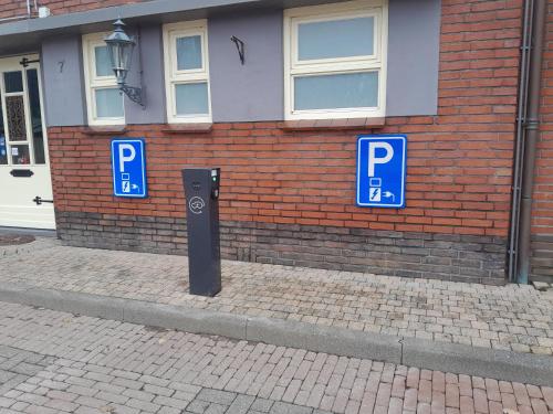 诺格诺格酒店的砖楼前的2个蓝色停车标志