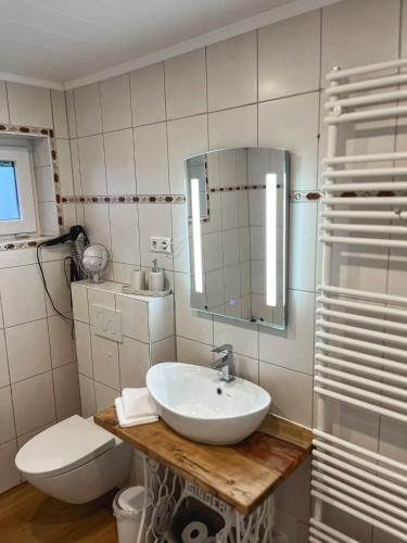 尼布尔Ferienwohnung Alida的一间带水槽、卫生间和镜子的浴室