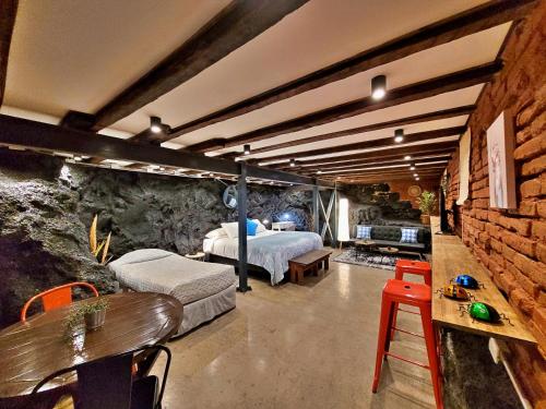 瓦尔帕莱索Maki Hostels & Suites Valparaiso的一间卧室设有两张床和砖墙