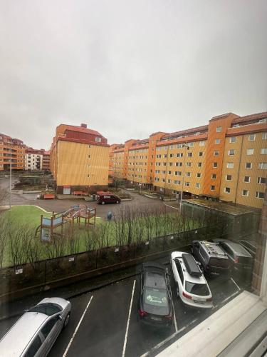 哥德堡Beautiful And Comfortable Apartment的停车场,停车场的汽车停在大楼前