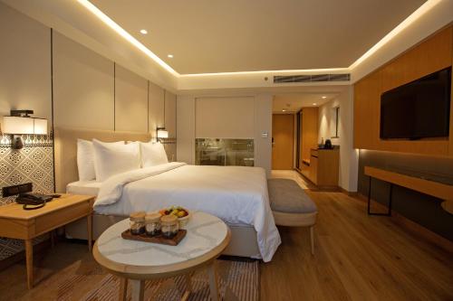 古瓦哈提ARISTA BY AMBITION的酒店客房设有一张大床和一张桌子。