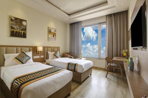 新德里Airport Hotel Claytone的酒店客房设有两张床和窗户。