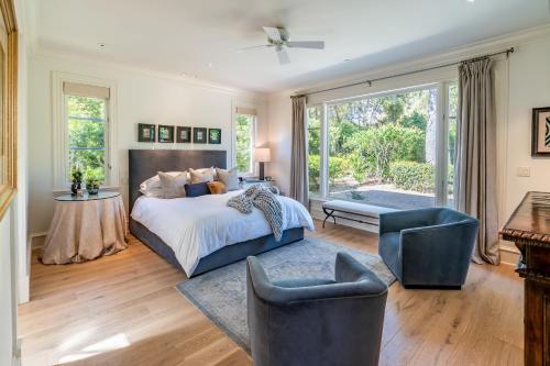 MontecitoLavish Montecito Home with Hot Tub, Patio and Gardens!的卧室配有一张床和一张桌子及椅子