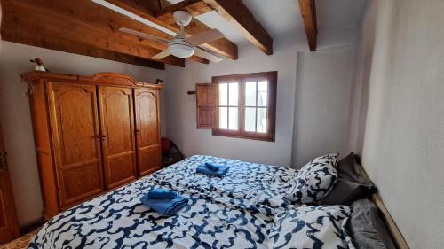 萨洛夫雷Inviting 1-bed house 'Esquina' Finca Vistamar的一间卧室配有一张床和一个木制橱柜