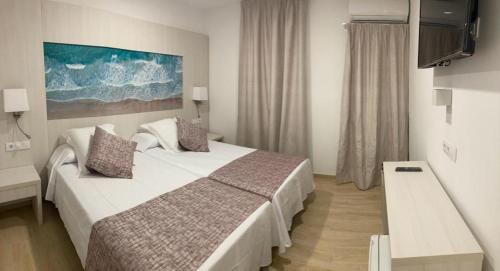 马略卡岛帕尔马Hotel Amic Colon的酒店客房,配有床和电视
