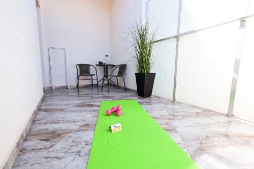 舒门RUBO Hotel的绿色的地板上放着一双粉色的鞋