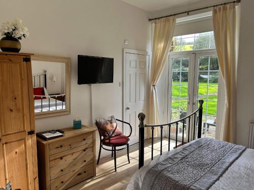 林顿Exmoor Manor Guest House的一间卧室配有一张床、梳妆台和镜子